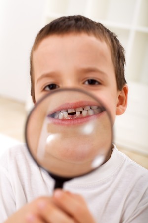 Boy with magnifier showing his first lost tooth - closeupの写真素材