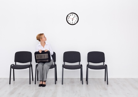 Still waiting for the job interview - woman checking timeの写真素材
