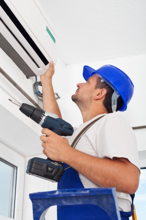 Worker installing air conditioning unit - closeupの写真素材