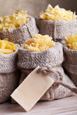 Pasta assortment in burlap bags - with pasta label for copy spaceの写真素材