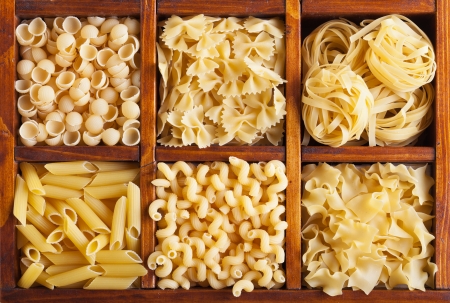 Pasta variety in wooden compartmented box - top viewの写真素材