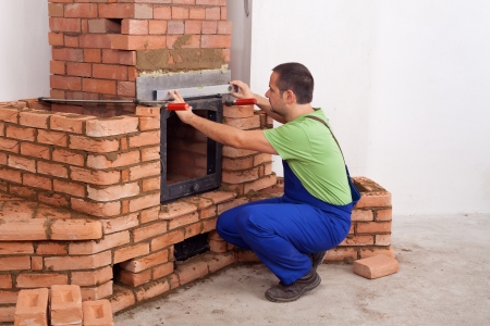 Worker building a masonry heater in a new home - copy spaceの写真素材