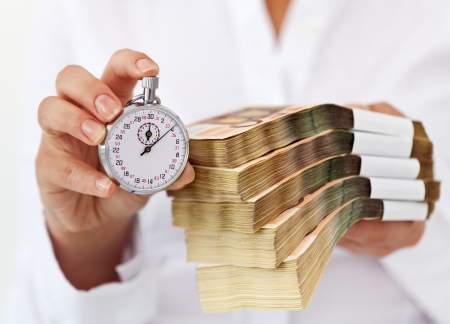 Limited time offer concept with stack of money and stopwatch in woman hands - shallow depth