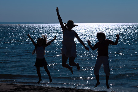 Finally we are here - happy morning jump on the sea shoreの写真素材