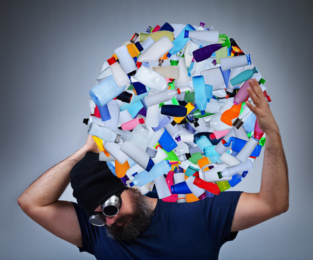 Burden of pollution - man carrying a globe made of plastic bottles, environmental destruction conceptの写真素材
