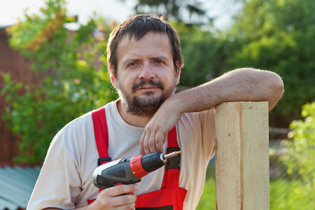 Handyman working in the yard - leaning on a fence supportの写真素材