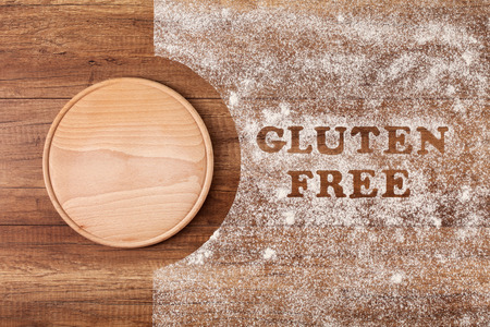 Gluten free words written in special flour sprinkled on wooden table - top view, copy spaceの写真素材