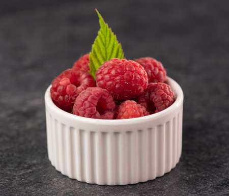 Raspberry fruits in small recipient - delicious summer fruit, close upの写真素材