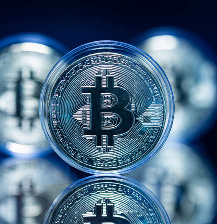 Digital currency concept - bitcoin on reflective surface in cool tones. Cryptocurrency investment opportunityの写真素材
