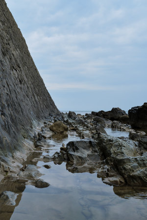 Rocks and blue sea. Side view of a huge mountain facing the ocean. Beautiful seascape.の写真素材