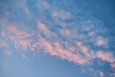 Minimalist landscape of the sky at dawn. Pink beautiful natural clouds in clear blue morning sky. Sunrise is silence and peace.の写真素材