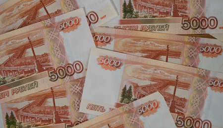 Russian paper banknotes with nominal value of five thousand rubles close-up view from above....