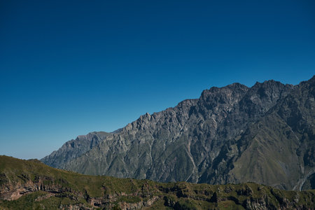 The Caucasus Mountains on the borders of Russia and Georgia. The village of Stepantsminda Kazbegi. Rocks and mountain peaks on a sunny warm summer day. beautiful landscapeの写真素材