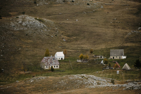 Cozy old houses in a small mountain village in the north of Montenegro - Durmitor National Park during the autumn season on a gray cloudy dayの写真素材
