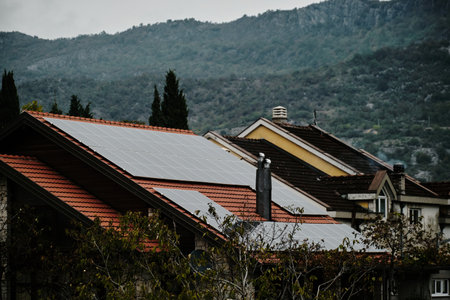 An old house with a tiled roof and modern solar panels. Technologies of the future, caring for the environment and saving electricity. A small village in the mountains of Montenegroの写真素材