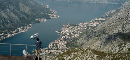 Young woman stands on an observation deck overlooking the Bay of Kotor. Rear view. The southernmost...
