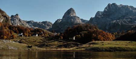 Bukumirsko Lake in the mountains of Montenegro, surrounded by colorful autumn forest and rugged...