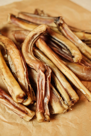 Natural dried bull pizzles - beef sticks - for dogs, arranged on kraft paper. Single-ingredient,...