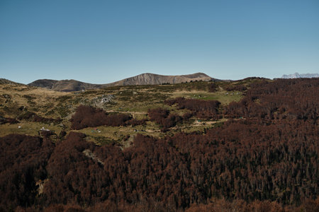 Panoramic view of the Komovi mountains in Montenegro during autumn. Rolling hills, scattered rural...