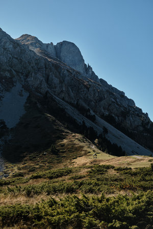 Small wooden cabin standing alone in the vast autumn landscape at the foot of Komovi mountains in Montenegro, surrounded by rocky peaks. A gazebo for relaxing at the foot of the mountainの写真素材