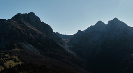 Dramatic rocky peak of Komovi mountain range in Montenegro under a clear blue sky at sunset....