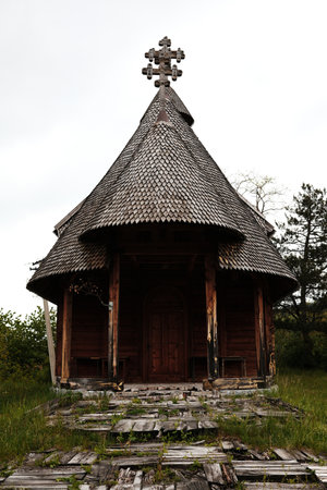 Traditional old wooden church on a hill under cloudy spring sky in Mokra Gora, Serbiaの写真素材