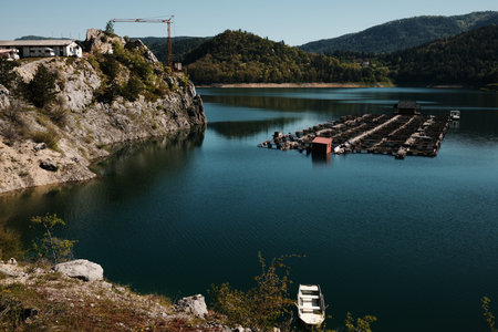 Tranquil view of Zaovine Lake with fish farms and a small boat in Tara National Park, Serbia in late springの写真素材