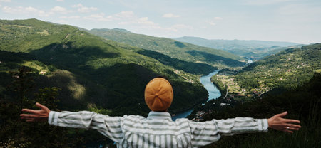Woman embracing the vast nature of Tara National Park with open arms, overlooking the winding Drina River below. Rear viewの写真素材