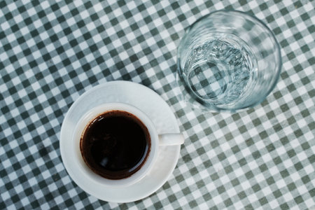 Serbian coffee and water served on a classic checkered tablecloth, a traditional Balkan combination. Top viewの写真素材