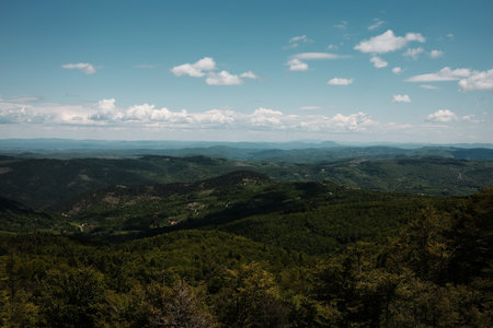 Wide panoramic view of the lush hills and distant ridges from the slopes of Mount Cigota, Serbiaの写真素材