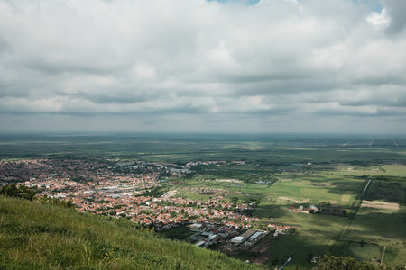 Wide panoramic view of Vrsac and surrounding Serbian countryside under a dramatic cloudy sky in springの写真素材