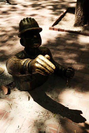 Playful bronze statue of a worker emerging from a manhole in Subotica, Serbia. The quirky public art...