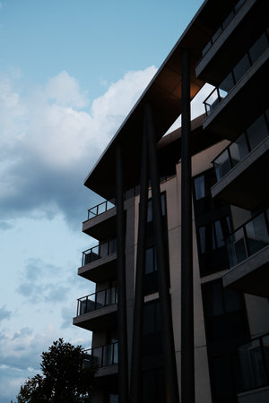 Stylish architectural detail of a modern residential building in Belgrade Waterfront, with tall dark...