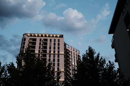 Tall illuminated residential tower in Belgrade Waterfront during twilight. Modern high-rise...