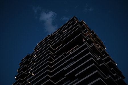 Dramatic perspective of modern high-rise building with glowing edges in Belgrade Waterfront at night.の写真素材