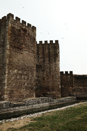 Stone towers and crenellated walls of Smederevo Fortress, Serbia, reflected in the surrounding moat. Medieval military architectureの写真素材