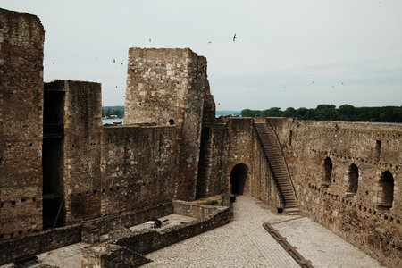 View of Smederevo Fortress courtyard and towers with arched windows, stairway and benches. Danube River visible in the backgroundの写真素材