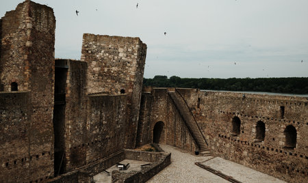 View of Smederevo Fortress courtyard and towers with arched windows, stairway and benches. Danube River visible in the backgroundの写真素材