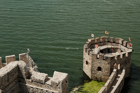 Close-up top view of a round stone tower with flags at Golubac Fortress on the Danube River, Serbia countryの写真素材