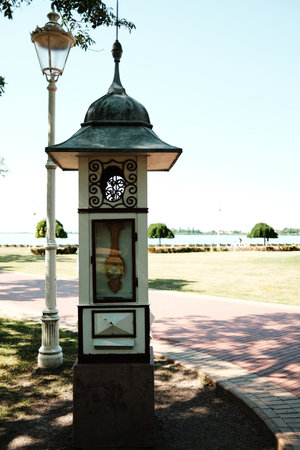 Ornamental weather station or thermometer in a decorative wooden kiosk in Palic park with lake in backgroundの写真素材