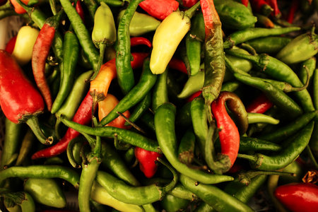 Spicy chili peppers in red, green, and yellow colors at the marketplace. Organic vegetables used for cooking, seasoning, and spicy dishesの写真素材