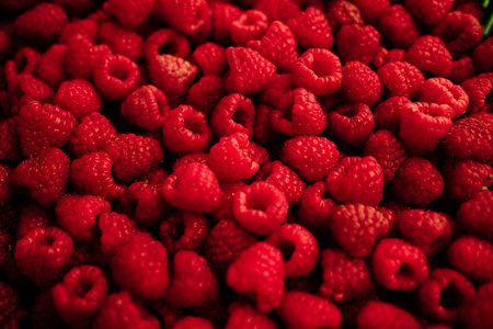 Fresh ripe raspberries piled at the local market. Organic red berries used in desserts, smoothies, and healthy dietsの写真素材