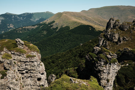 Rocky cliffs and green slopes of Stara Planina with mountain ridges in the distance. Babin Zub mount in summer season. Serbia countryの写真素材