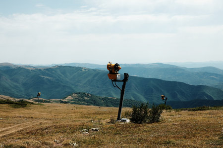 Snowmaking machine on Stara Planina meadow with vast mountain ranges and green valleys in the background. Serbia countryの写真素材