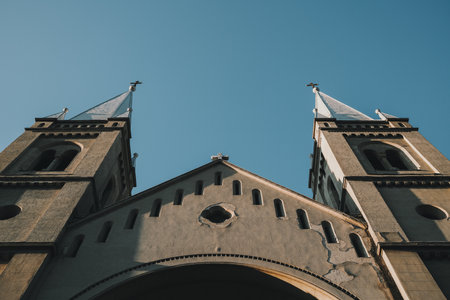 Low angle view of twin church towers in Subotica, Serbia, under clear blue sky in winterの写真素材