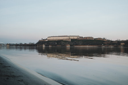 Danube Riverbank in Novi Sad with a calm winter view of Petrovaradin Fortress reflecting on the waterの写真素材