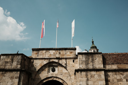 Kalemegdan Fortress gate in Belgrade with Serbian and other flags on a sunny day