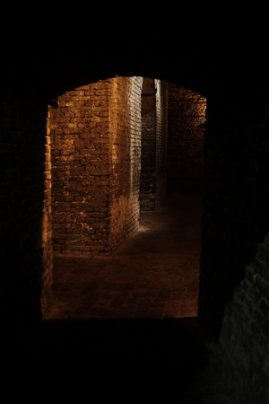Dark underground brick passage in Kalemegdan Fortress, Belgrade, with dramatic lighting on old stone wallsの写真素材