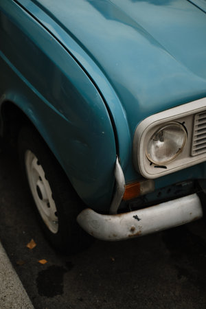 Close-up of old blue classic car showing headlight, bumper and fender detailsの写真素材