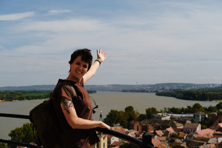 Female traveler pointing towards Belgrade and Danube River from Gardos Tower viewpoint in Zemunの写真素材